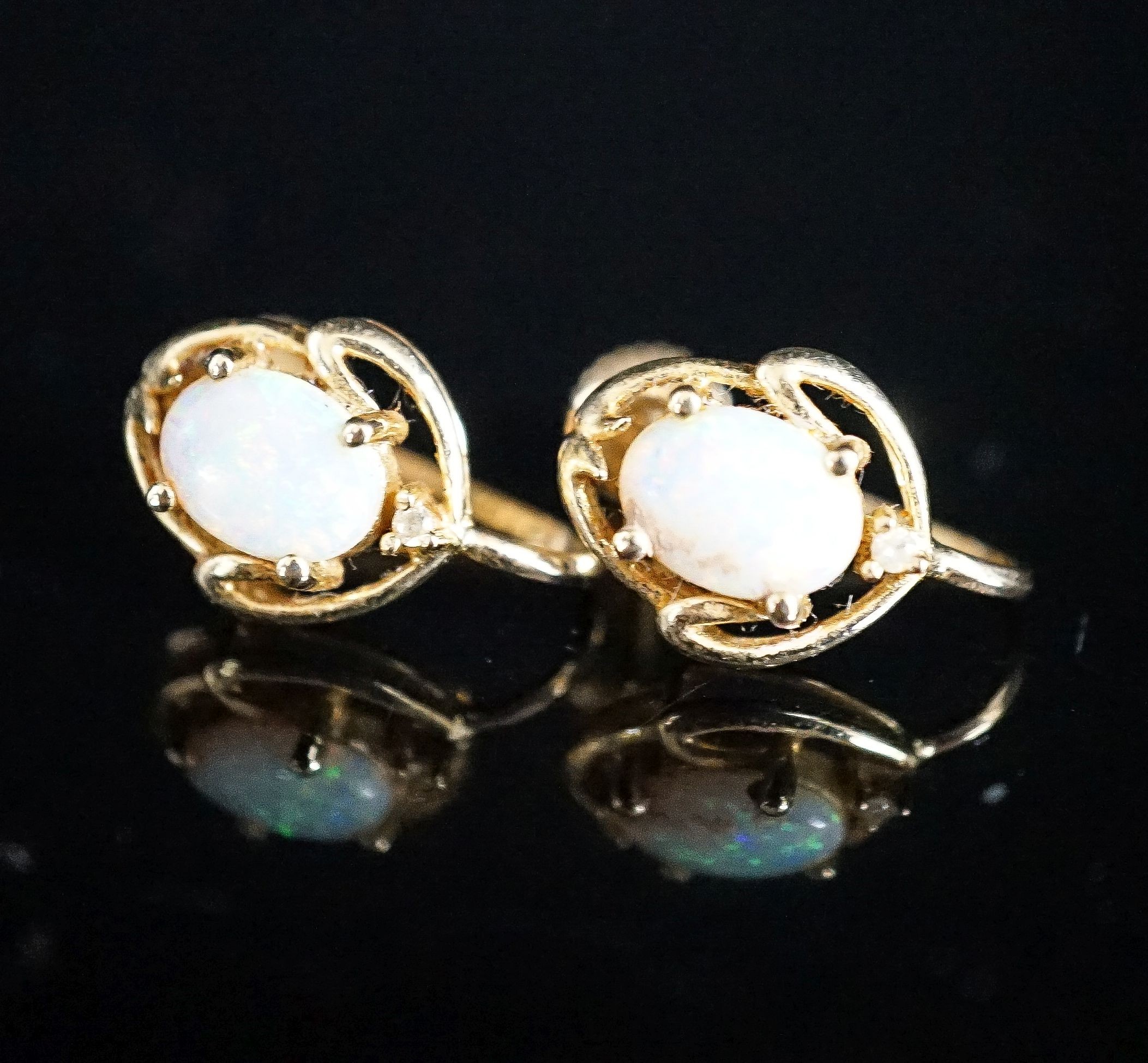 A modern pair of 585 yellow metal and oval white opal set ear clips, 12mm, gross weight 3.2 grams.
